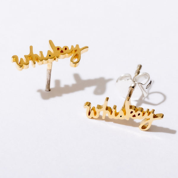 Gold Whiskey Script Stud Earrings by Larissa Loden against a white background.