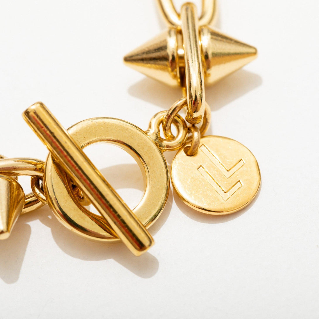 Close Up of Gold Barbed Wire Spiked Necklace White Background 